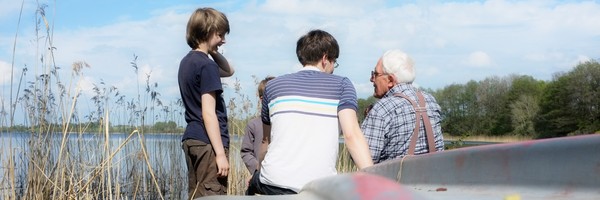 verschiedene Generationen einer Familie sprechen miteinander am See